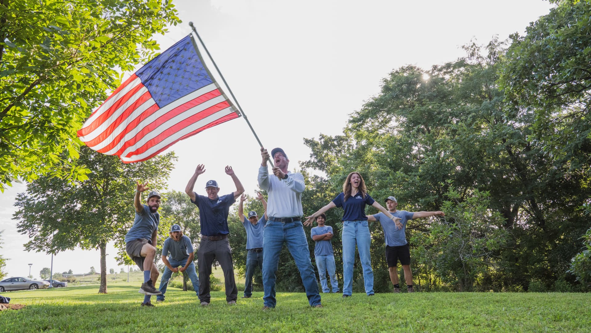 The Aubrey Co. crew cheering together with an American flag